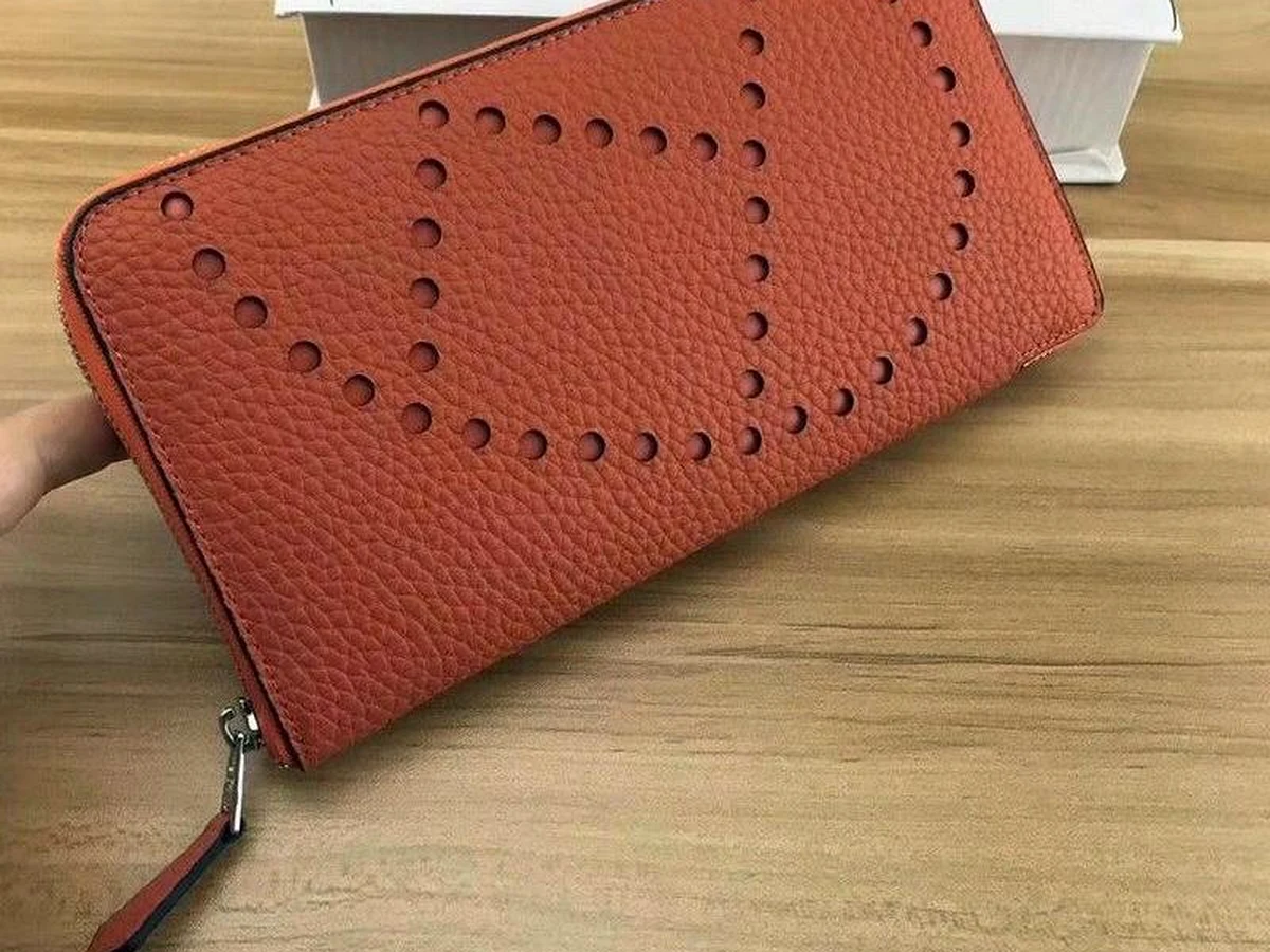 Portefeuille Hermès en cuir grainé orange avec motif perforé